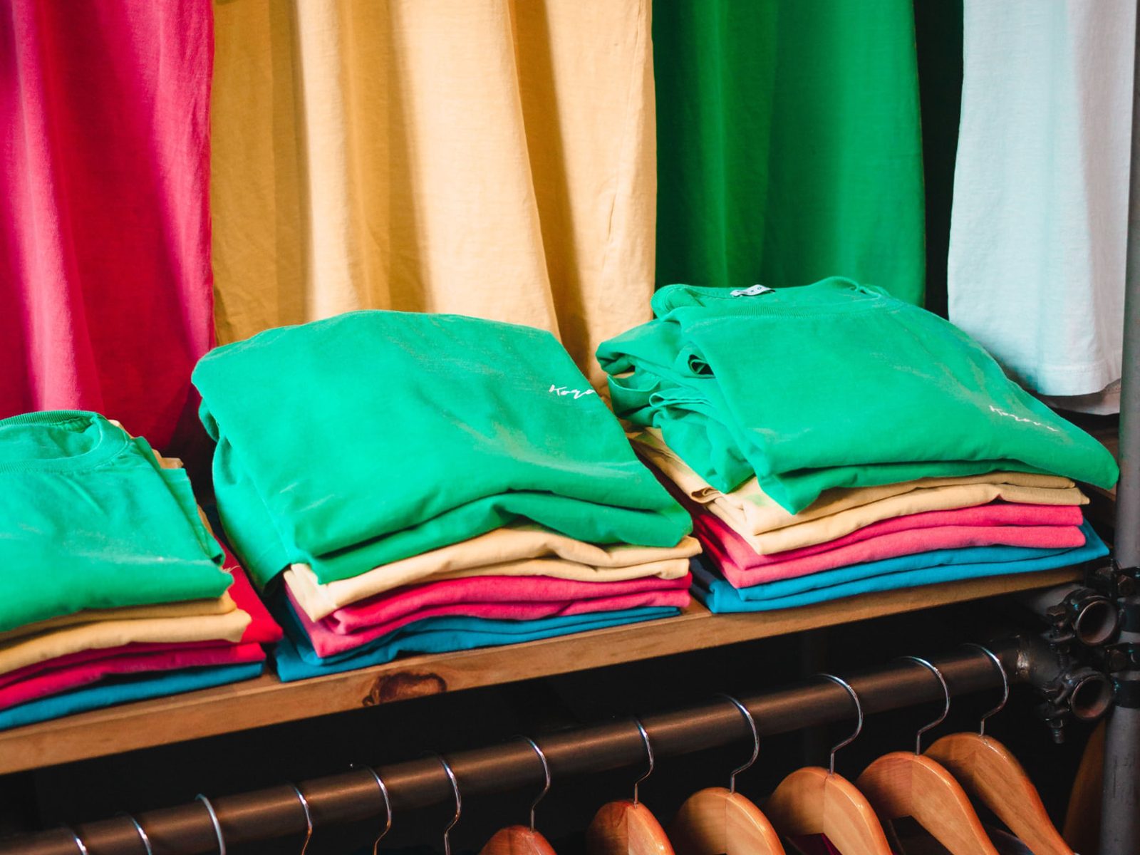 Stacks of custom printed t-shirts in multiple colors